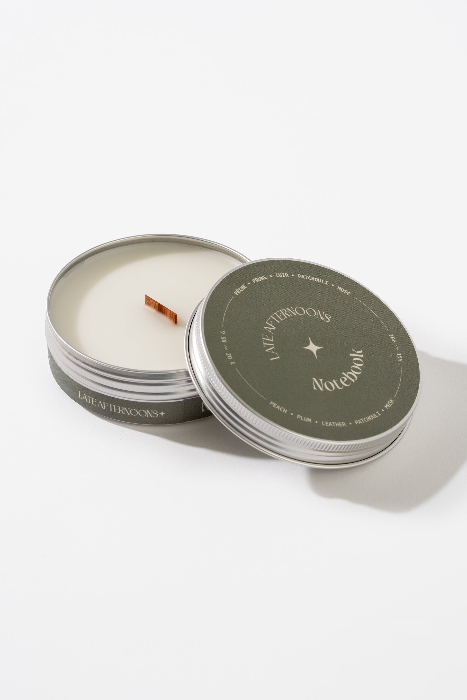 Candle in a tin with 'Notebook' branding on a white background