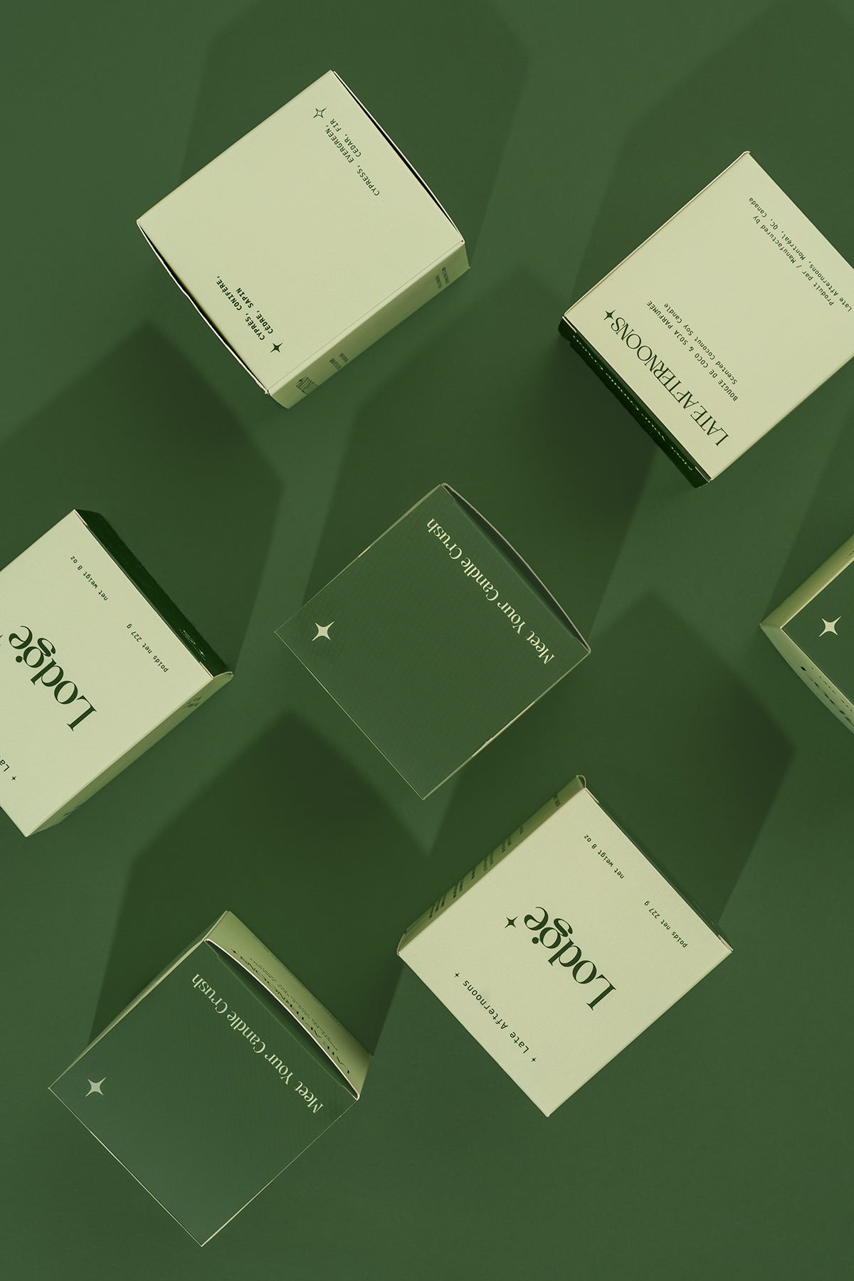Lodge candle packaging boxes styled on a green background by Late Afternoons