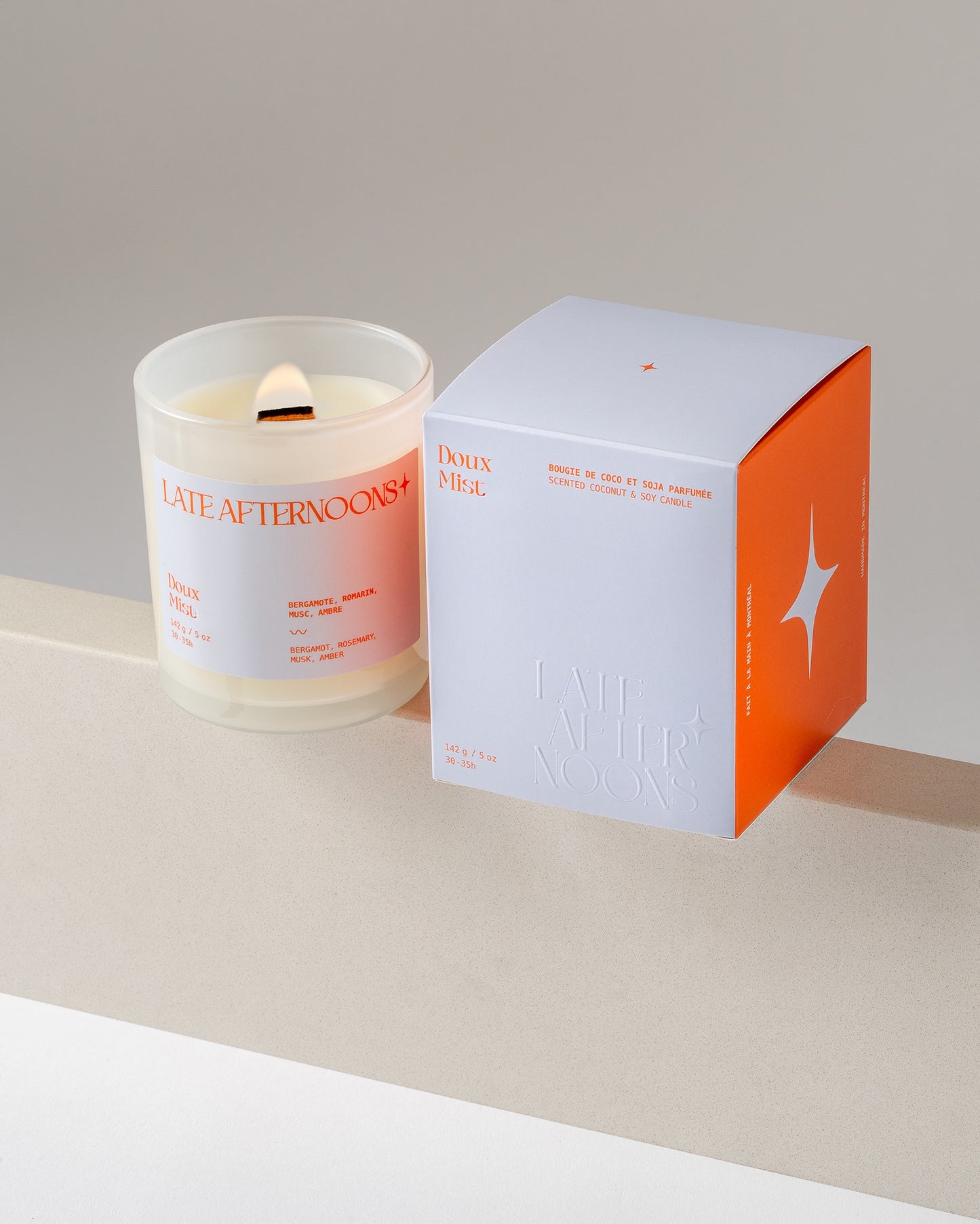 Doux Mist candle lit beside its blue and orange box, hand-poured coconut soy by Late Afternoons