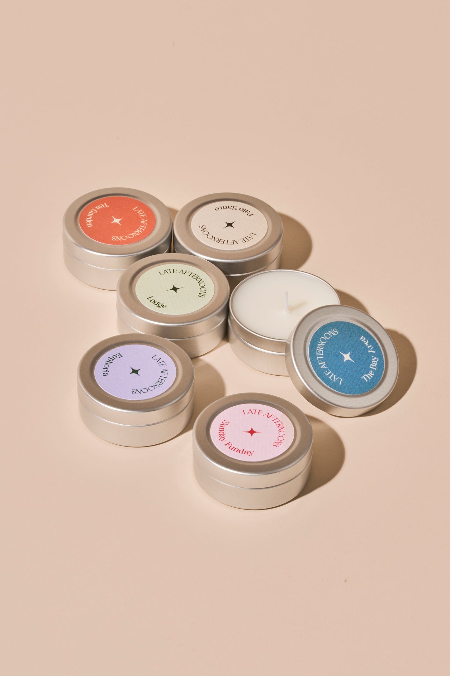 Mini Crush discovery kit, six mini tin candles with coloured lids on a pink background